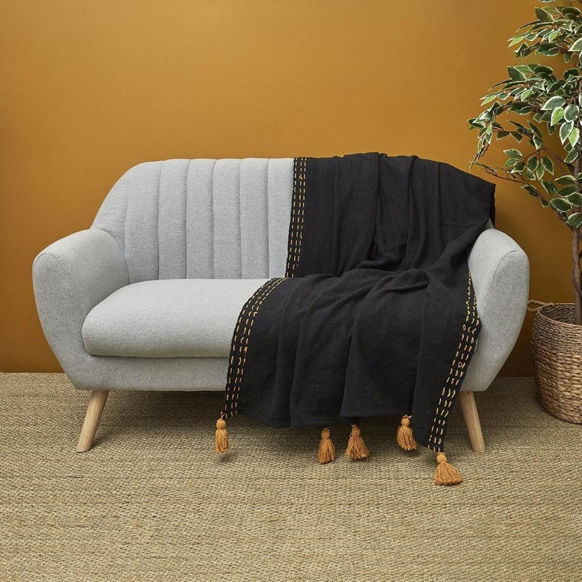 The Home Deco Factory Jeté de canapé surpiqué pompons noir 130x150 cm